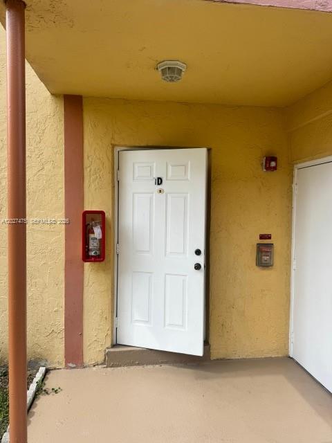 A white door labeled 1D is set in a yellow exterior wall with a fire extinguisher — 2850 NW 55th Ave # 1D, Lauderhill FL 33313, LAUDERHILL, FL