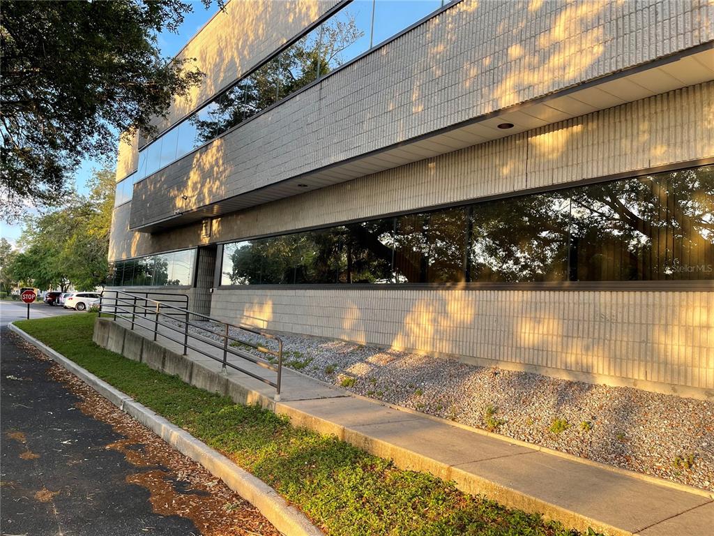 An exterior view of a multi-story commercial building with a concrete ramp and glass windows — 9555 SEMINOLE BOULEVARD UNIT 001, SEMINOLE, FL