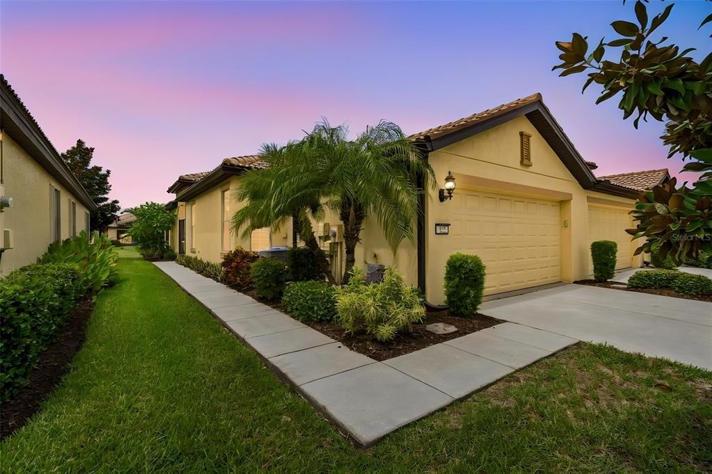 A single-story house with a tan stucco exterior, a two-car garage, and a palm tree — 322 MYSTIC FALLS DRIVE, APOLLO BEACH, FL