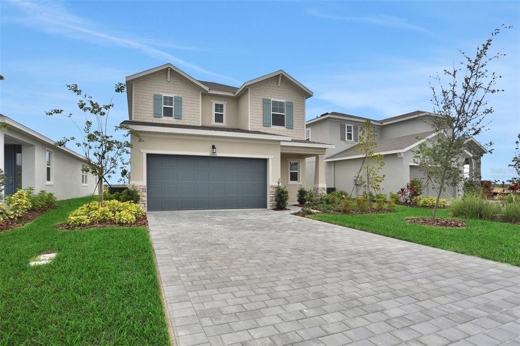 A two-story suburban house with a gray garage door and a paved driveway — 13461 TURNLEAF BOULEVARD, PUNTA GORDA, FL