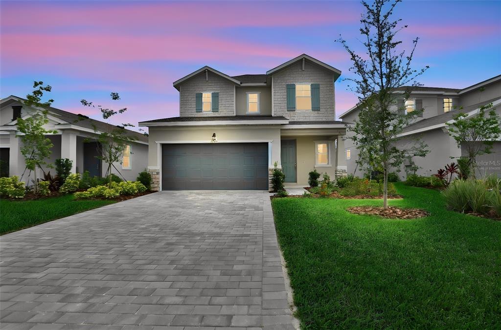 A two-story suburban house with a paved driveway, a two-car garage, and a grassy lawn — 13461 TURNLEAF BOULEVARD, PUNTA GORDA, FL