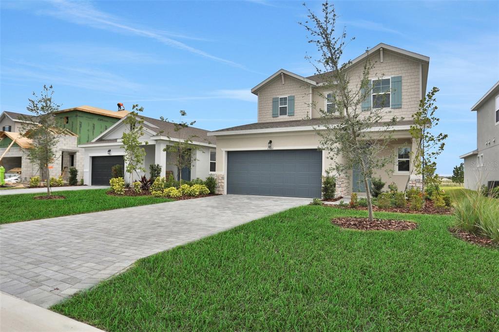 A two-story suburban house with a gray garage door and a paved driveway — 13461 TURNLEAF BOULEVARD, PUNTA GORDA, FL