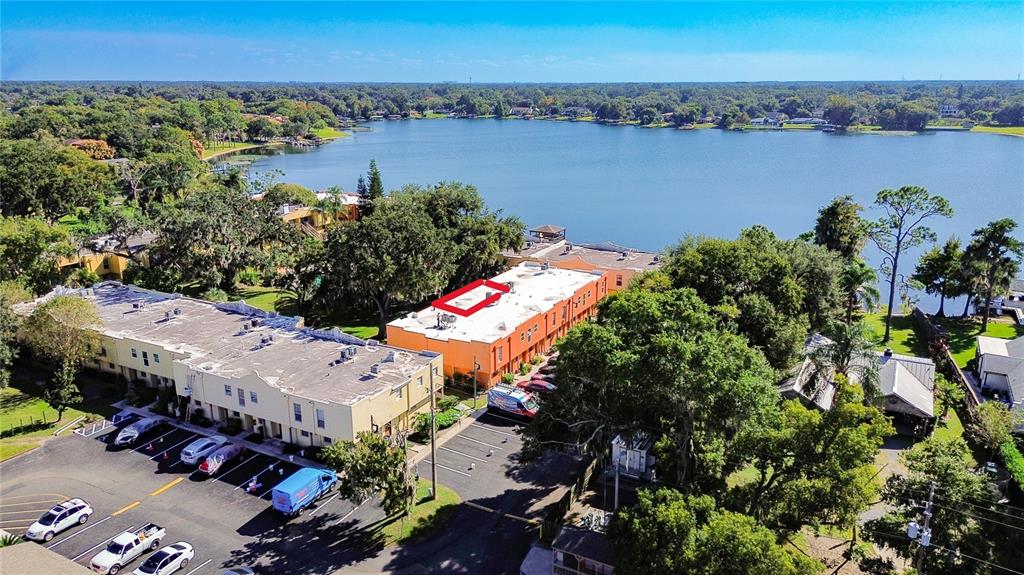 An aerial view shows a multi-story apartment building with a red-outlined roof by a lake — 772 E MICHIGAN STREET UNIT 70, ORLANDO, FL