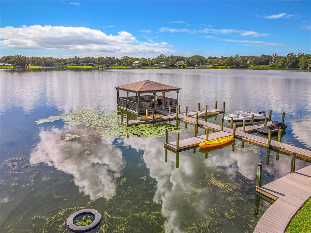 A wooden dock with a gazebo extends into a lake with kayaks and a boat — 772 E MICHIGAN STREET UNIT 70, ORLANDO, FL