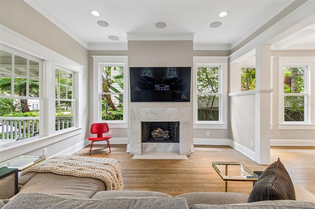 A living room features a marble fireplace, a wall-mounted television, and a red accent chair — 712 S ORLEANS AVENUE, TAMPA, FL