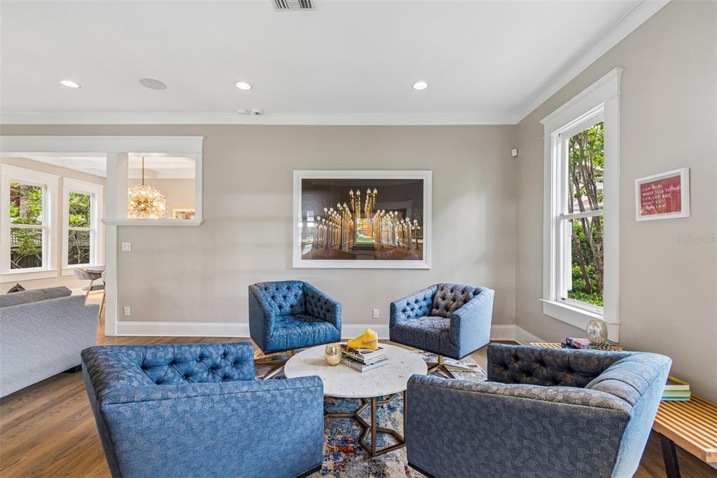 A living room features four blue tufted armchairs arranged around a round marble coffee table — 712 S ORLEANS AVENUE, TAMPA, FL