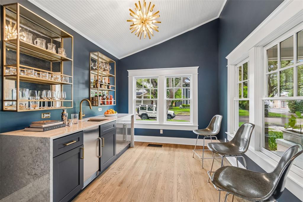 A modern home bar with dark blue walls, gold shelving, and three metallic bar stools — 712 S ORLEANS AVENUE, TAMPA, FL
