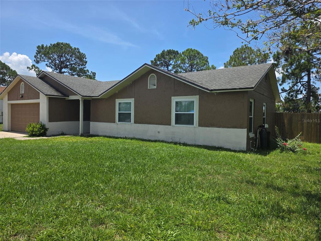 A brown, single-story house with a two-car garage and a white stucco base — 2473 BECK CIRCLE, DELTONA, FL