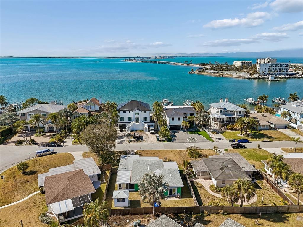 A kitchen features dark lower cabinets, white upper cabinets, granite countertops, and a farmhouse sink — 2427 BAYWOOD DRIVE W, DUNEDIN, FL