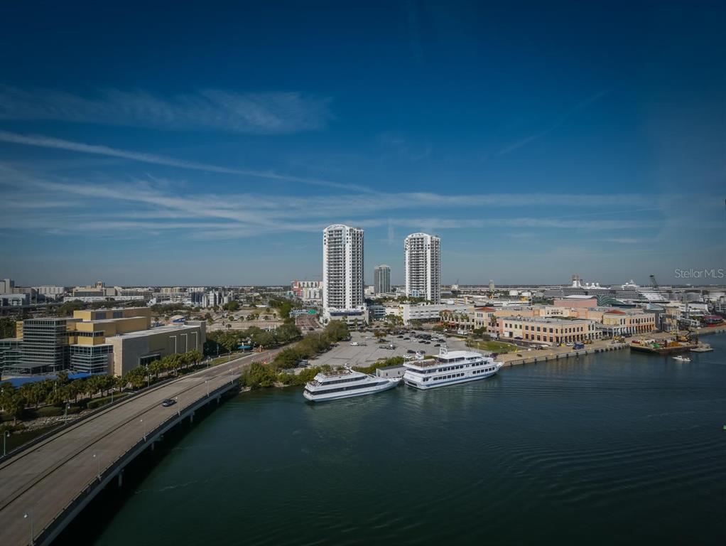 An aerial view of a waterfront area featuring two tall towers, boats, and a bridge — 600 GARRISON COVE LANE UNIT 2B, TAMPA, FL