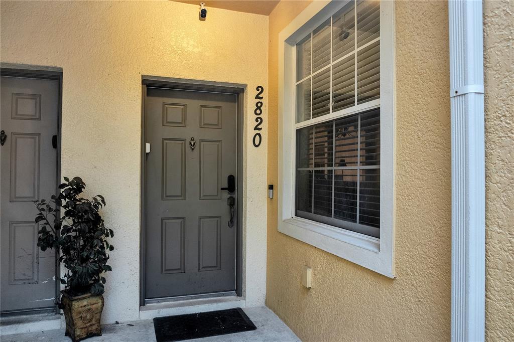 A row of yellow townhouses with attached garages and a white SUV parked in front — 2820 OAKWATER DRIVE UNIT 2820, KISSIMMEE, FL
