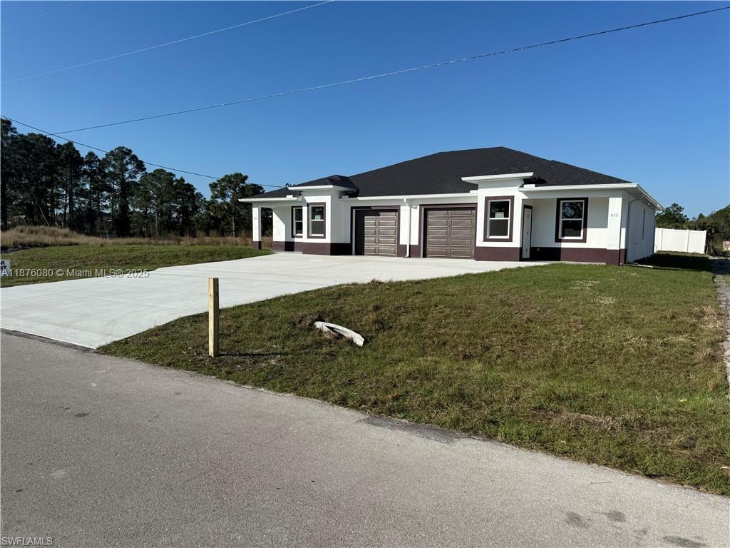 A newly constructed single-story duplex with white stucco walls and two attached garages — 832 HOLMES AVE # 832, Lehigh Acres FL 33974, LEHIGH ACRES, FL