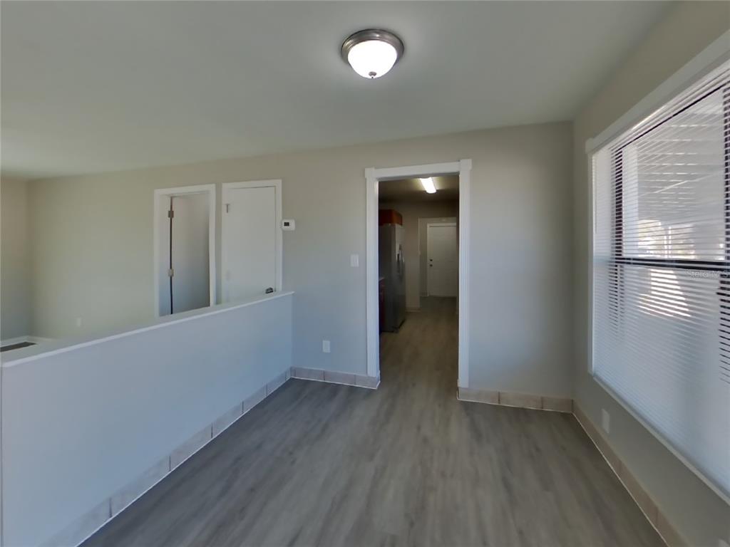 A room with light gray walls, wood-look flooring, a ceiling light, and a doorway — 1122 IBSEN AVENUE, ORLANDO, FL