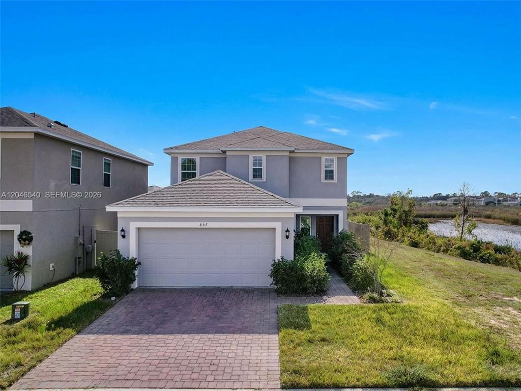 A two-story gray house features a two-car garage and a brick driveway — 857 SCRUB OAK HAMMOCK ROAD, DAVENPORT, FL