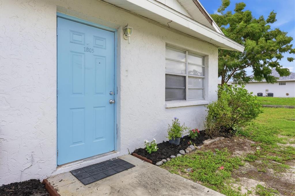 A light blue front door with the number 1805 sits on a white stucco exterior — 1805 MARBETH STREET UNIT 1805/1807, SARASOTA, FL