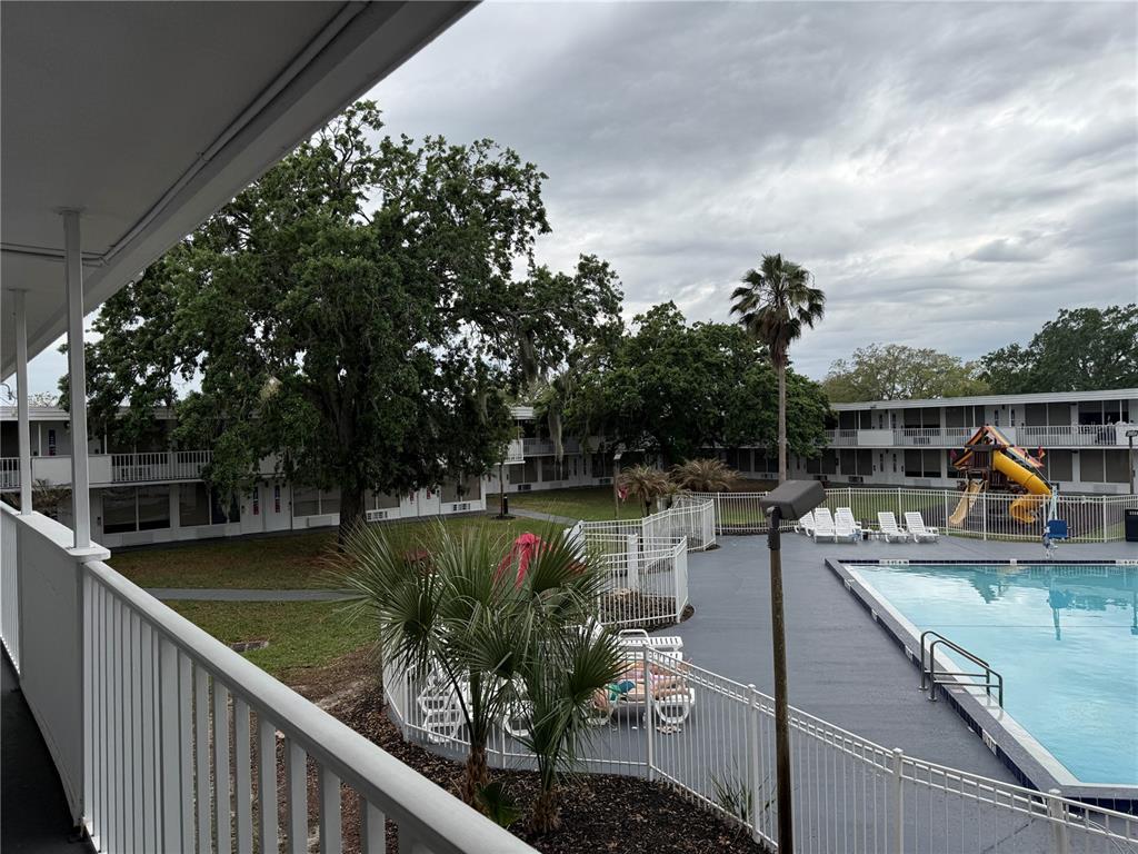 An elevated view of a motel courtyard featuring a swimming pool and playground — 2930 POLYNESIAN ISLES BOULEVARD UNIT 233, KISSIMMEE, FL