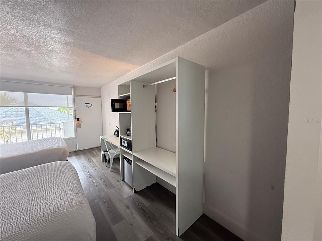 A hotel room features two beds, a white open closet unit, and a desk area — 2930 POLYNESIAN ISLES BOULEVARD UNIT 233, KISSIMMEE, FL