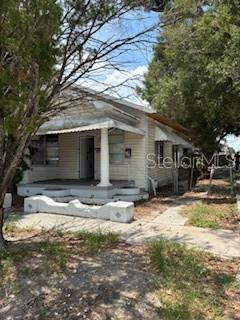 A single-story house with light-colored siding, a front porch, and a concrete walkway — 1401 E 24TH AVENUE, TAMPA, FL