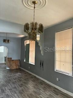 A room with gray walls, wood-look flooring, a large chandelier, and a window with blinds — 1401 E 24TH AVENUE, TAMPA, FL