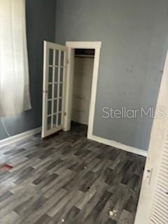 A bedroom with gray walls, wood-look flooring, a French door, and an open closet — 1401 E 24TH AVENUE, TAMPA, FL