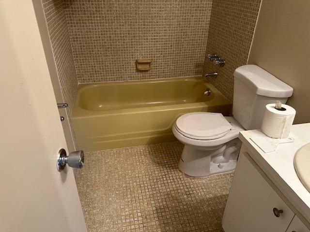A bathroom features a yellow bathtub, a white toilet, and tan mosaic tile flooring — 7605 NW 5th Place # 106, Margate FL 33063, MARGATE, FL