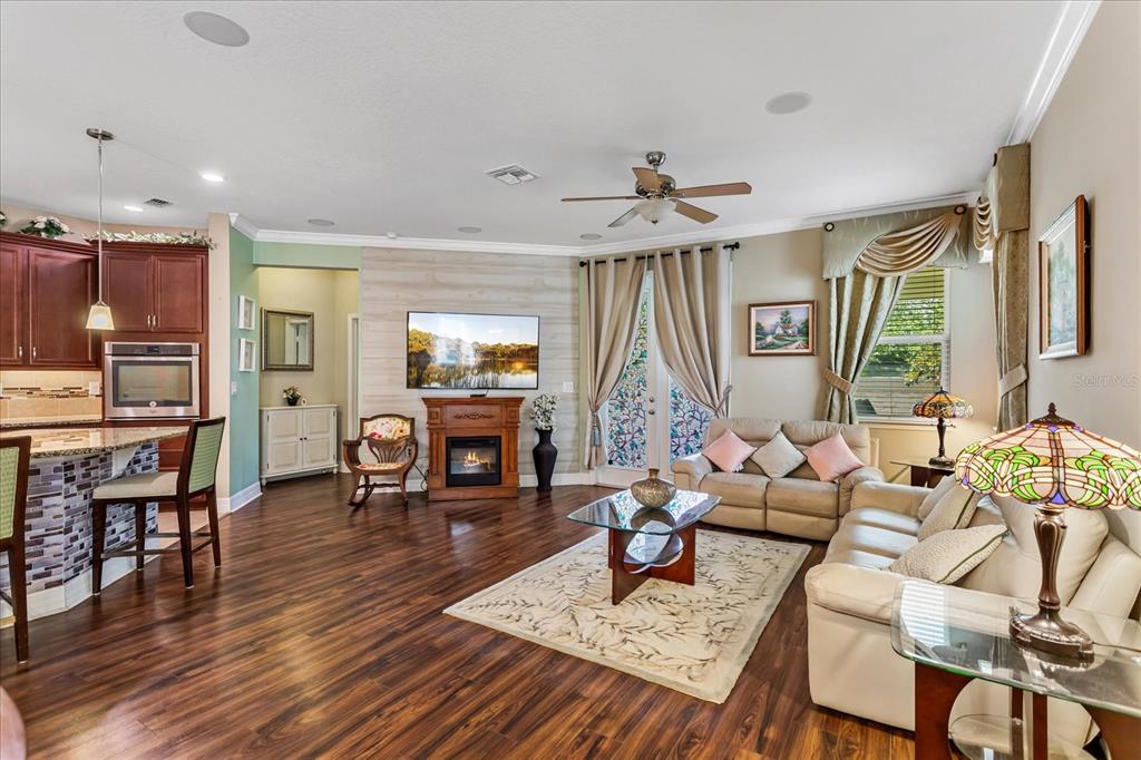 A living room with wood floors, a fireplace, a television, and a kitchen island — 4914 GRASSENDALE TERRACE, SANFORD, FL