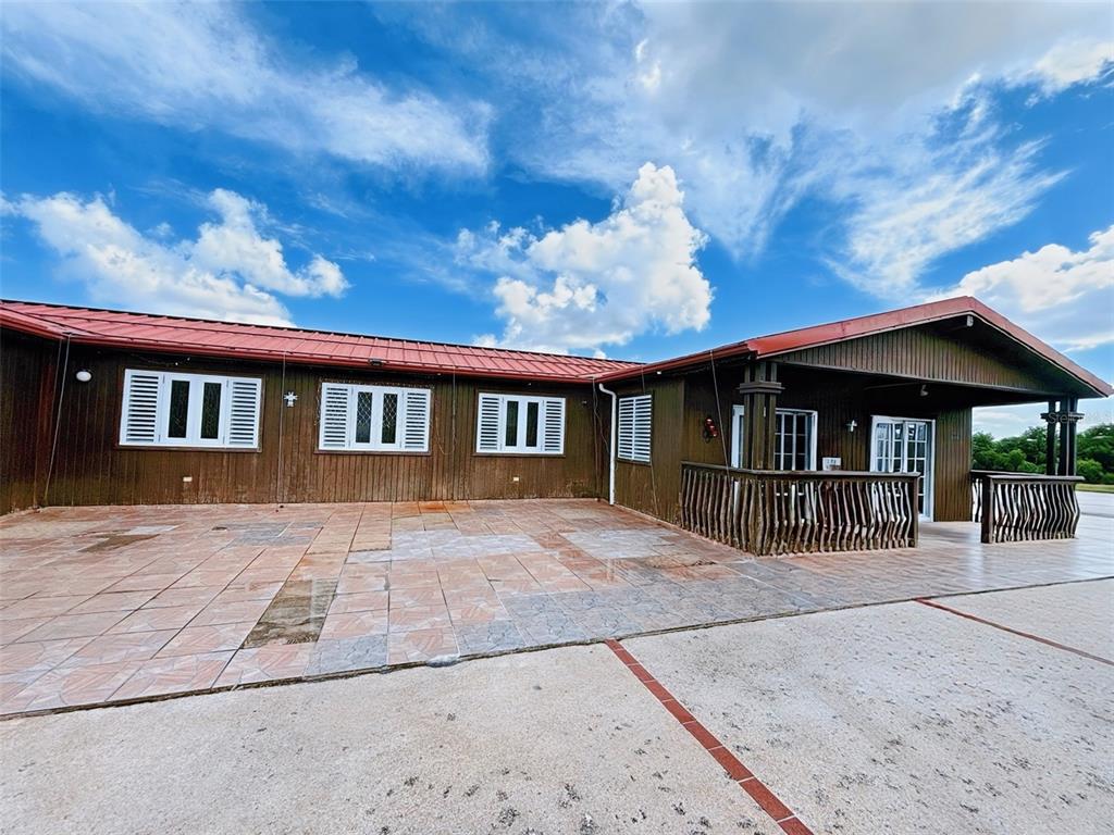 A brown wood-sided building with a red metal roof and a tiled patio area — CARRETERA 779 KM 9.9 INT. BO. CEDRO ARRIBA, NARANJITO, PR