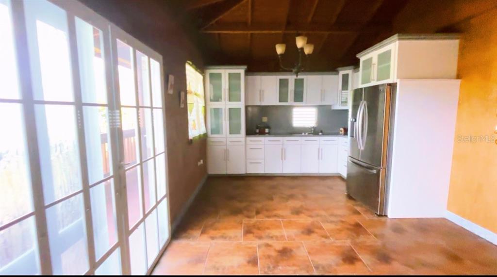 A kitchen with white cabinets, stainless steel appliances, and brown tiled flooring — CARRETERA 779 KM 9.9 INT. BO. CEDRO ARRIBA, NARANJITO, PR