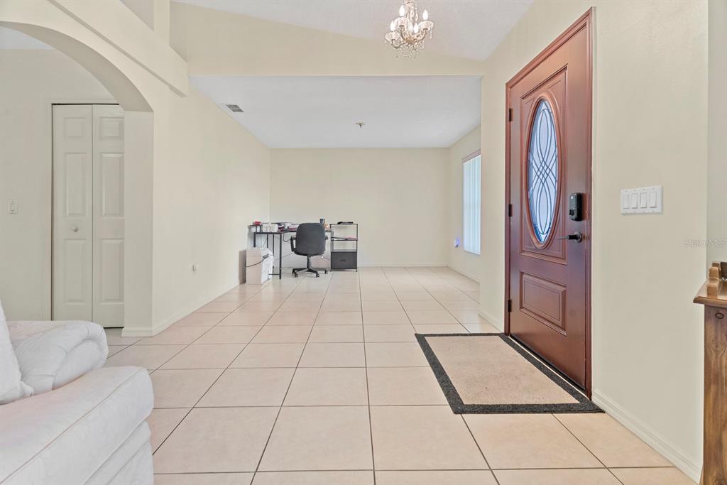An entryway with tile flooring leads to an open living area featuring a home office — 640 FAIRHAVEN STREET, DELTONA, FL