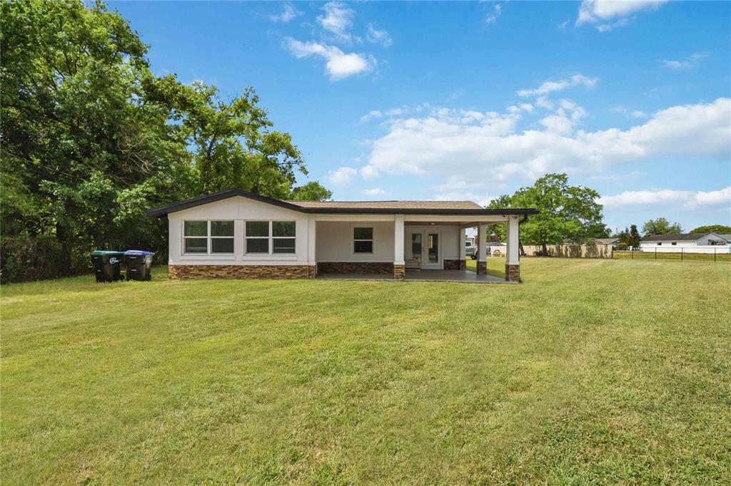 A single-story house with a covered patio and stone accents sits on a grassy lot — 4116 S GOLDENROD ROAD, ORLANDO, FL