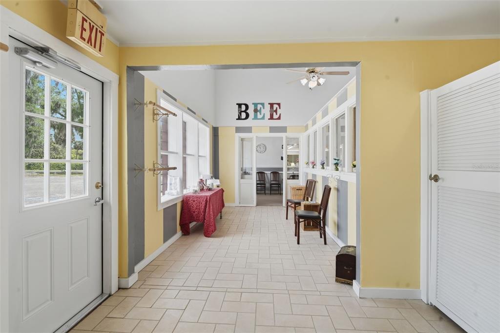 A sunroom features yellow walls with gray stripes, tile flooring, and a "BEE" wall sign — 1030 CAMPHOR LANE, DELAND, FL