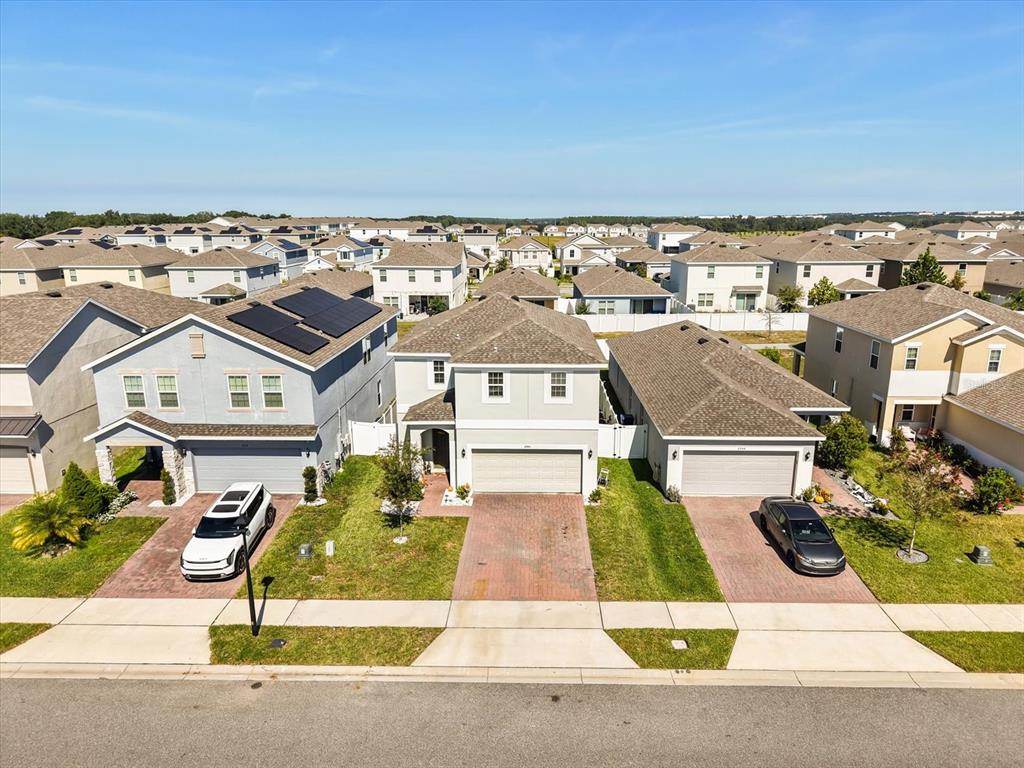 An aerial view shows three suburban houses with driveways and lawns on a sunny day — 6940 CHURCH LAKE STREET, GROVELAND, FL