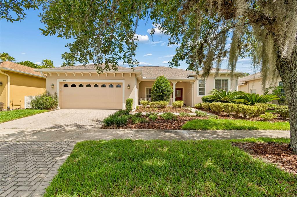 A single-story house with a beige stucco exterior, a two-car garage, and a landscaped yard — 478 BALBOA DRIVE, KISSIMMEE, FL