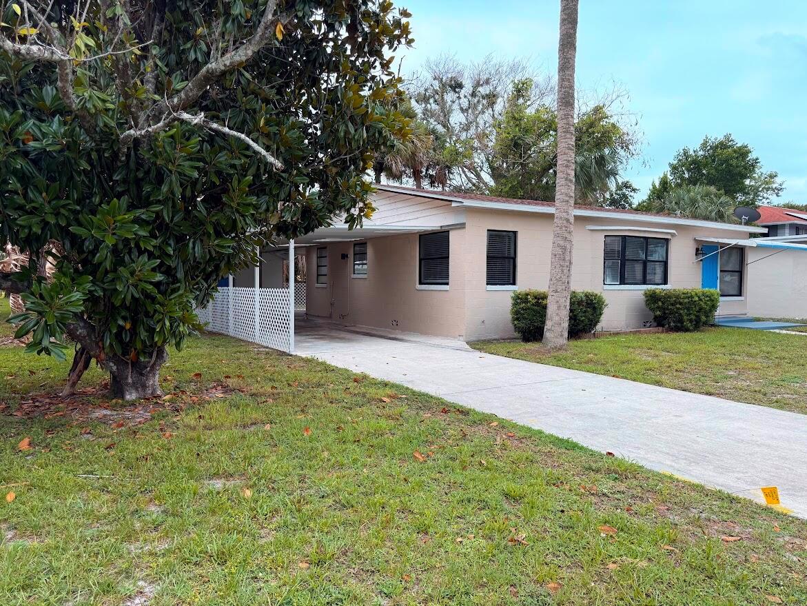 A single-story house with a beige exterior, a carport, and a concrete driveway — 1010 Mayflower Road, Fort Pierce FL 34950, FORT PIERCE, FL
