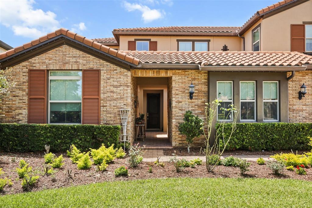 A single-story house with a stone facade, brown shutters, and a tiled roof — 16614 HARBOR SAIL WAY, WINTER GARDEN, FL