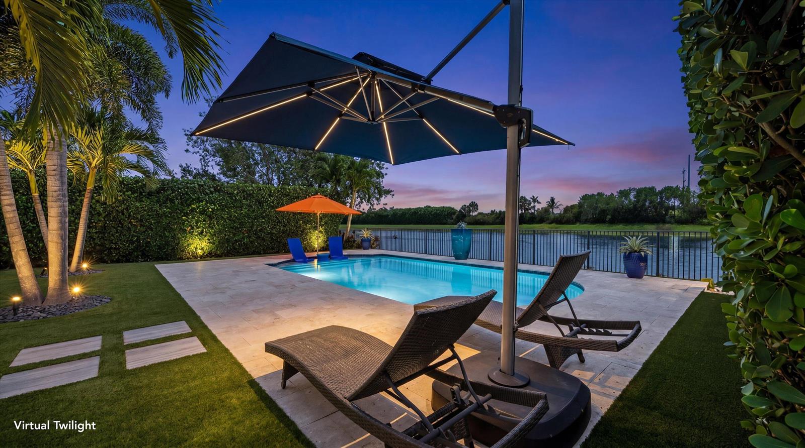 A swimming pool with lounge chairs and a large umbrella at dusk — 8779 Grand Prix Lane, Boynton Beach FL 33472, BOYNTON BEACH, FL