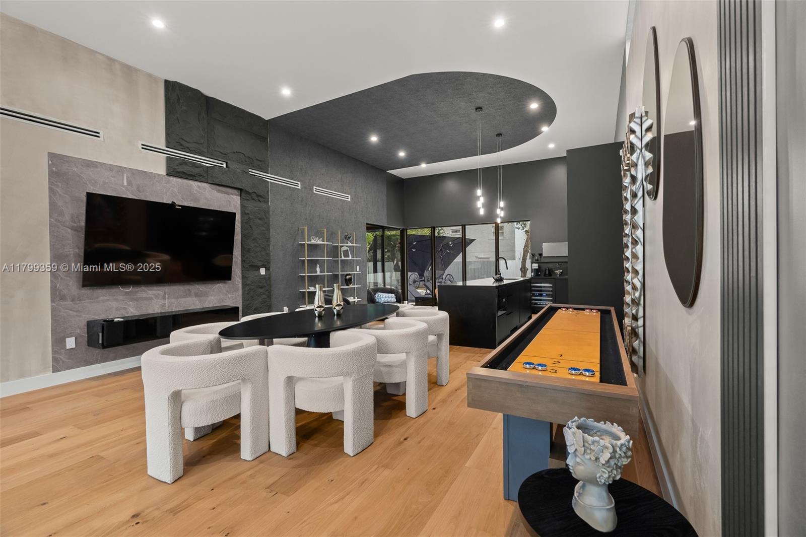 A modern living room features a dining area, shuffleboard table, and dark stone accent walls — 400 NW 49th St # 0, Miami FL 33127, MIAMI, FL
