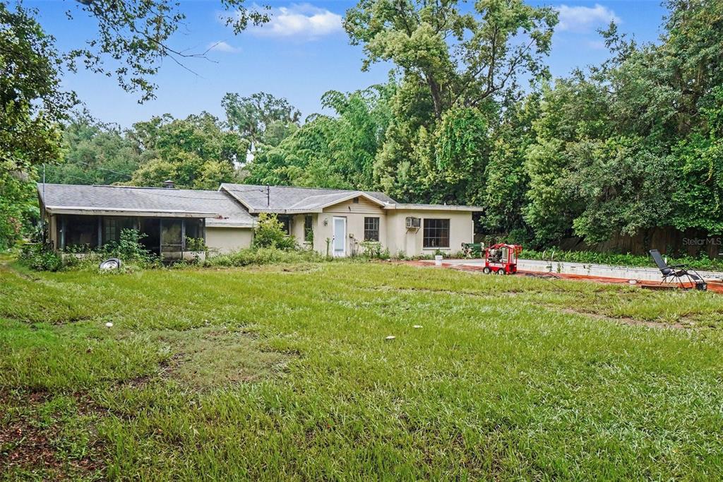 A single-story house with a screened porch and a backyard pool sits among mature trees — 3220 GARDNER ROAD, LAKELAND, FL