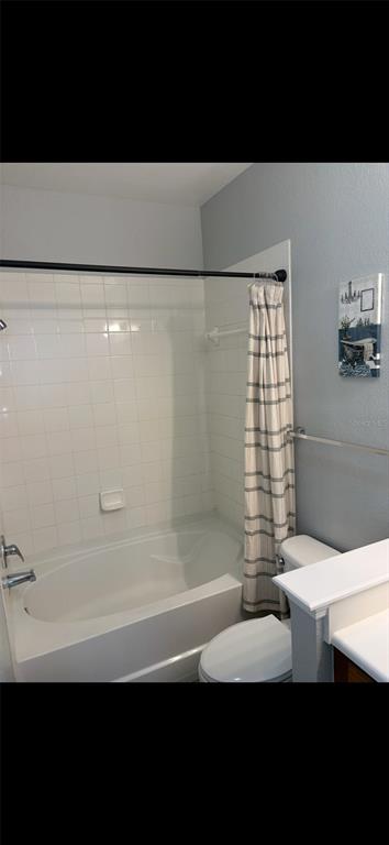 A bathroom features a white tiled shower-tub combination, a toilet, and a vanity — 8103 LILLIES WAY UNIT 108, ORLANDO, FL