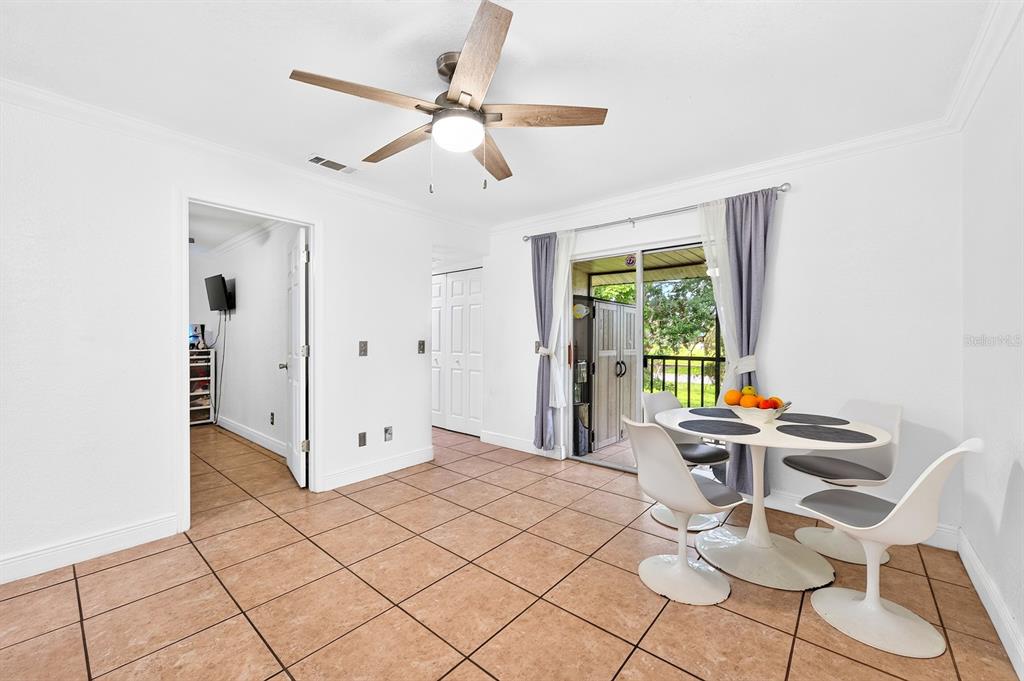 A dining area with tile floors, a ceiling fan, and sliding glass doors to a patio — 4336 HECTOR COURT UNIT 7, ORLANDO, FL