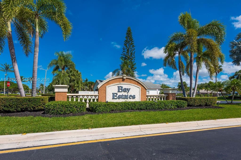 A sign for Bay Estates stands in a landscaped area with palm trees and grass — 6256 Lansdowne Cir, Boynton Beach FL 33472, BOYNTON BEACH, FL