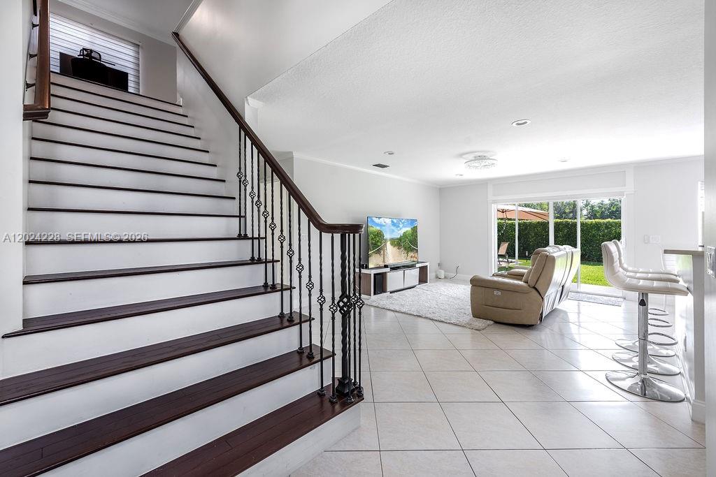 A living room features a staircase with dark wood treads and a white tile floor — 6256 Lansdowne Cir, Boynton Beach FL 33472, BOYNTON BEACH, FL
