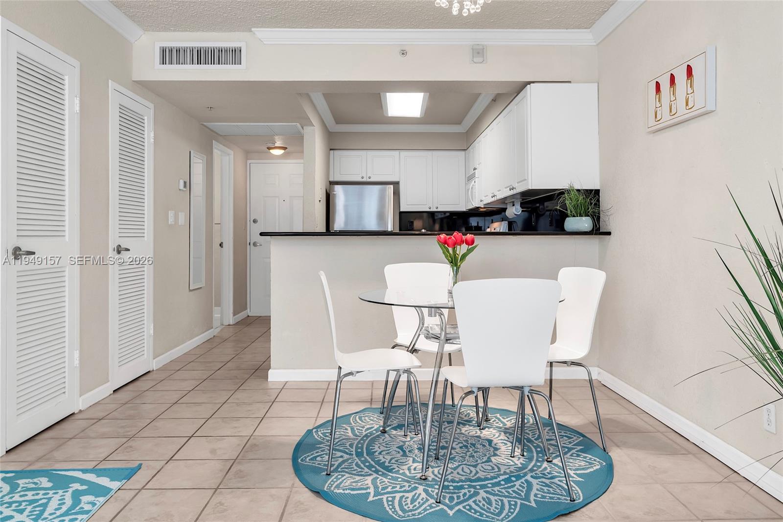 A dining area with a glass table and chairs sits in front of a kitchen — 2501 S Ocean Dr # 534, Hollywood FL 33019, HOLLYWOOD, FL