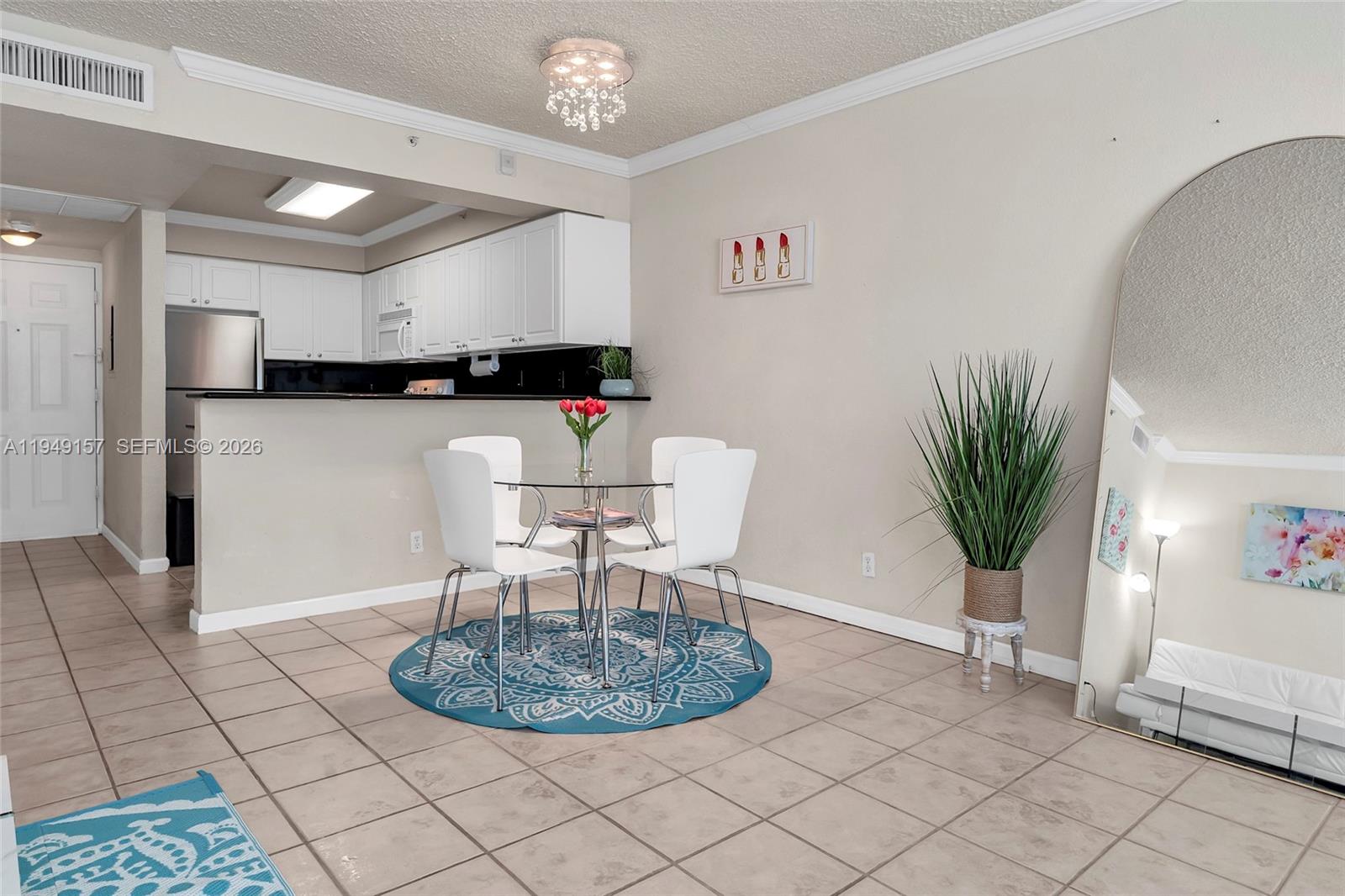A dining area with a glass table and white chairs sits before an open kitchen — 2501 S Ocean Dr # 534, Hollywood FL 33019, HOLLYWOOD, FL