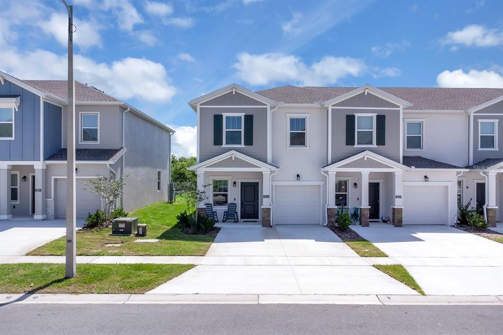 A row of modern two-story townhouses with gray siding, white trim, and attached garages — 2845 PIERR STREET, DAVENPORT, FL