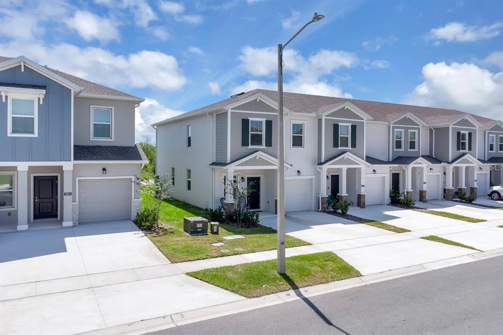 A row of two-story townhomes with gray siding, white trim, and attached garages — 2845 PIERR STREET, DAVENPORT, FL