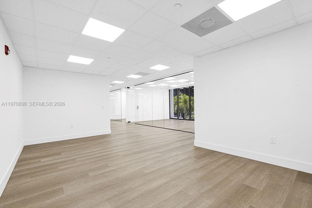 An empty office space features white walls, light wood-look flooring, and glass-walled conference rooms — 1110 Brickell Ave # 310A, Miami FL 33131, MIAMI, FL