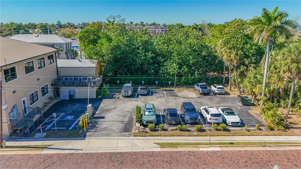 An aerial view shows a parking lot next to a multi-story building with trees — 252 W MARION AVENUE UNIT 113 & 115, PUNTA GORDA, FL