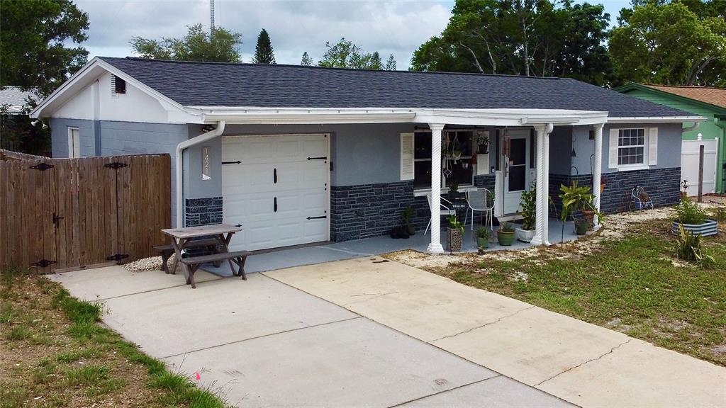 A single-story gray house with a white garage door, covered porch, and concrete driveway — 1421 WICKHAM LANE, HOLIDAY, FL