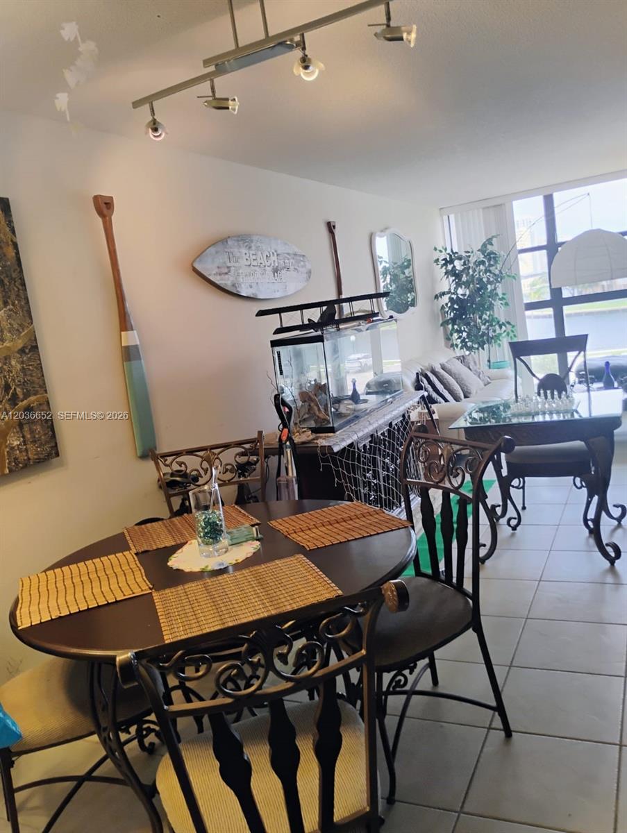A dining area features a round table and chairs, a fish tank, and beach-themed decor — 200 Leslie Dr # 324, Hallandale Beach FL 33009, HALLANDALE BEACH, FL